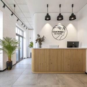 Okrągłe logo na ścianę z ilustracją dłoni i stopy